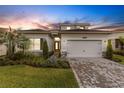 Beautiful single-Gathering home with a well-manicured lawn at dusk at 32740 Tree Of Life Ave, Wesley Chapel, FL 33543