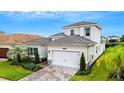 Well-maintained two-story home with a brick driveway and lovely landscaping at 32740 Tree Of Life Ave, Wesley Chapel, FL 33543