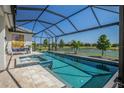 Stunning screened-in pool area overlooking a pond, with spa and plenty of room for outdoor entertaining at 4754 Manning Ct, Sarasota, FL 34240