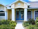 Inviting home entrance with double doors, decorative wreath and well-manicured garden at 4875 Hansard Ave, North Port, FL 34286
