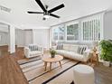 Bright living room featuring hardwood floors, modern furniture, large windows, and a contemporary ceiling fan at 5225 20Th N St, St Petersburg, FL 33714