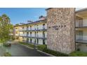 Condo building with stone accent wall, white railing and exterior hallway access at 6100 12Th S St # 313, St Petersburg, FL 33705