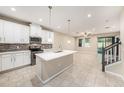 Bright, open kitchen with white cabinets, an island with pendant lights and stainless steel appliances at 6703 Citrus Creek Ln, Tampa, FL 33625