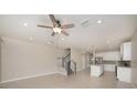 Open concept living room featuring tile flooring, a ceiling fan, and open access to the kitchen at 6703 Citrus Creek Ln, Tampa, FL 33625