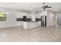 Spacious, open-concept living area with tile floors, abundant natural light, and view to the kitchen at 7308 Hermes Ct, Apollo Beach, FL 33572