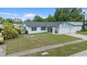 Single-story home with blue accents, two-car garage, and a lush green lawn at 14506 Sutter Pl, Tampa, FL 33625