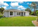 Attractive single-story home with large arched windows, a two-car garage, and lush green lawn at 2706 Flagami Ln, North Port, FL 34286