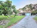 A charming home featuring a well-maintained lawn, mature trees, and a long driveway at 663 68Th S Ave, St Petersburg, FL 33705