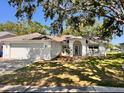Charming single-story home featuring a well-manicured lawn, classic white exterior, and an inviting arched entryway at 7342 Skyview Ave, New Port Richey, FL 34653