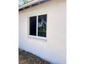 Exterior shot showcasing a white-framed window set against a textured white wall at 7342 Skyview Ave, New Port Richey, FL 34653