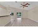 Open living space with tiled flooring, a ceiling fan, and sliding glass doors leading to a lanai at 22802 Roderick Dr, Land O Lakes, FL 34639