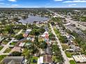 Expansive aerial view of a residential neighborhood showcasing a property with mature trees and a nearby lake at 9033 3Rd N St, St Petersburg, FL 33702