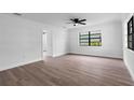 Bright, airy bedroom features a modern ceiling fan, freshly painted walls, and wood-look laminate flooring at 9033 3Rd N St, St Petersburg, FL 33702