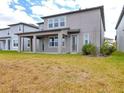 A shot of the backyard showing the grass, the covered patio and a view of the neighboring property at 3137 Marine Grass Dr, Wimauma, FL 33598