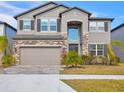 Charming two-story home featuring stone accents, a well-manicured lawn, and a two-car garage at 3137 Marine Grass Dr, Wimauma, FL 33598