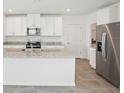 Bright kitchen with granite countertops, stainless steel appliances, and white cabinets offer style and functionality at 3550 Moscato Dr, Brooksville, FL 34602