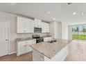 Modern kitchen with stainless steel appliances, granite countertops, and white cabinets at 3921 Radiant Mountain Dr, Plant City, FL 33565