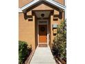 Inviting entryway features a brown door with wreath and well-maintained landscaping at 7544 Red Mill Cir, New Port Richey, FL 34653