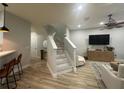 Open-concept living room with staircase, wood floors, and modern furnishings at 7544 Red Mill Cir, New Port Richey, FL 34653