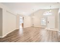 Bright, open-concept living area featuring vaulted ceilings and wood-look flooring at 4305 Balmoral Ct, Wesley Chapel, FL 33543