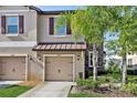 Inviting townhome exterior with a beige facade, stone accents, and a well-manicured front lawn at 11632 Castine St, New Port Richey, FL 34654