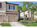 Charming townhome with a beige stucco exterior, stone accents, and lush green landscaping at 11632 Castine St, New Port Richey, FL 34654