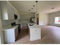 Well-lit kitchen featuring a center island, pendant lighting, stainless steel appliances, and modern cabinetry at 353 Warrington Blvd, Port Charlotte, FL 33954