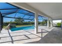 Screened-in pool area featuring a rock waterfall, hot tub, and travertine patio for relaxing at 4861 Antrim Dr, Sarasota, FL 34240