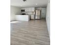 Bright living room featuring a kitchen with stainless steel appliances, white cabinets, and modern countertops, plus updated floors at 8612 N Alaska St, Tampa, FL 33604