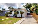 Beautiful home exterior featuring manicured lawn, decorative landscaping, and a long driveway with garage at 2456 S 17Th S Ave, St Petersburg, FL 33712
