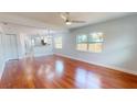 Spacious living room with gleaming hardwood floors, large windows, and an open view to the updated kitchen at 2456 S 17Th S Ave, St Petersburg, FL 33712