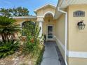 Close-up of a home's entrance featuring a well-kept garden and freshly painted exterior at 7337 Cone Shell Dr, Spring Hill, FL 34607