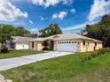 Exterior view of a charming single-story home with a manicured lawn and two car garage at 7337 Cone Shell Dr, Spring Hill, FL 34607