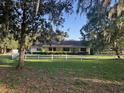 Landscaped ranch with a white fence, offering a serene and inviting curb appeal at 17380 Sweetwater Rd, Dade City, FL 33523