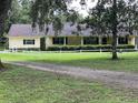 Charming ranch-style home with covered front porch and verdant landscaping at 17380 Sweetwater Rd, Dade City, FL 33523