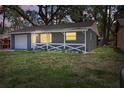 Beautiful single-story home with a covered porch and a one car garage at dusk at 7214 Oakwood Dr, New Port Richey, FL 34652