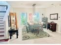 Bright dining room with large windows, modern chandelier and staircase access at 18018 Malakai Isle Dr, Tampa, FL 33647