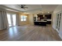 Open-concept living room featuring hardwood floors, a modern ceiling fan, and a view to the kitchen at 3269 Ponce De Leon Blvd, North Port, FL 34291