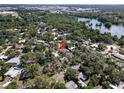 Wide aerial view of a neighborhood with lush trees and a lake in the distance at 404 Courtney Dr, Temple Terrace, FL 33617