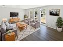 Cozy living room with gray furniture, decorative rug, and plenty of natural light from the large windows at 7604 Tyson Dr, Port Richey, FL 34668