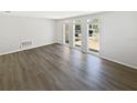Spacious living room with large windows and modern wood-look flooring at 7604 Tyson Dr, Port Richey, FL 34668