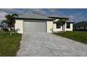 Paver driveway leads to a spacious two-car garage with a well-maintained front lawn at 9 Bunker Pl, Rotonda West, FL 33947