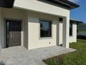 Modern home exterior featuring a covered entrance and a dark front door with stone pavers at 9 Bunker Pl, Rotonda West, FL 33947