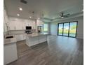 Open-concept kitchen with white cabinets, a large island, stainless appliances, and hardwood floors at 9 Bunker Pl, Rotonda West, FL 33947