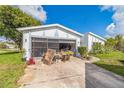 Quaint home featuring white paint, gray trim, and a garage with a screened door at 18430 Alphonse Cir, Port Charlotte, FL 33948