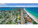 An aerial shot displays the home's location relative to the beach and surrounding waterfront community at 16107 Gulf Blvd, Redington Beach, FL 33708