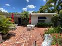 Quaint brick patio with outdoor seating, shaded by palm trees, ideal for enjoying the outdoors at 16107 Gulf Blvd, Redington Beach, FL 33708
