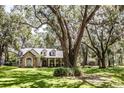 Beautiful single-story home with a stone exterior and inviting front porch, set amidst mature trees and a well-manicured lawn at 2906 Country Breeze Dr, Plant City, FL 33567