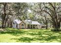 Single-story home with stone accents, dormer windows and inviting front porch, with detached garage and mature tree shaded lawn at 2906 Country Breeze Dr, Plant City, FL 33567