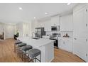 Modern kitchen featuring white cabinets, stainless steel appliances, and a large island at 1240 Baywood Dr, North Port, FL 34288